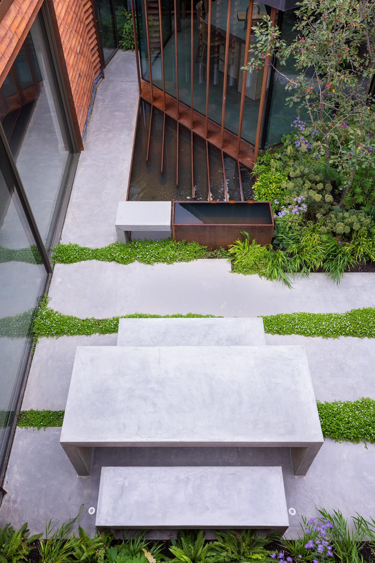 Colm Joseph Cambridge modern designer Petersen bricks corten steel water feature concrete table and benches naturalistic planting view from above